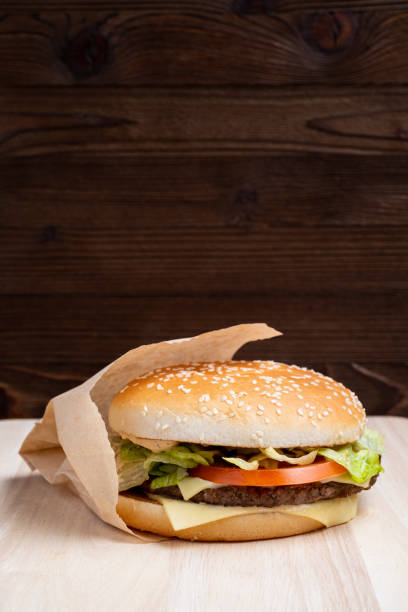 istock Burger general view from the side on a wooden background. Close up. 1213284220