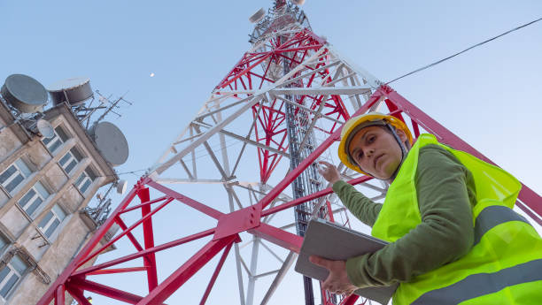 istock Female Engineer working on the field near a Telecommunications tower. 1213293013