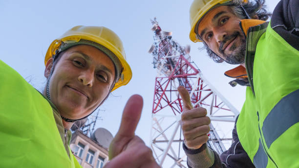istock Engineers working on the field near a Telecommunications tower. Teamwork. 1213293135