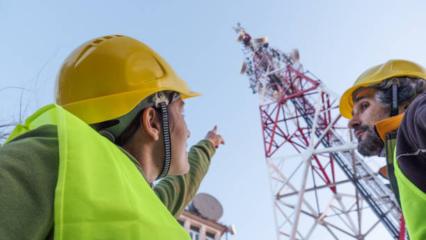 istock Engineers working on the field near a Telecommunications tower. Teamwork. 1213293155