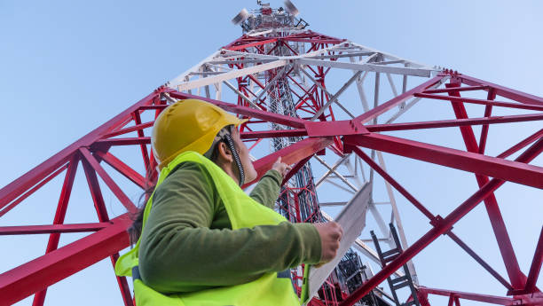 istock Female Engineer working on the field near a Telecommunications tower. 1213293169