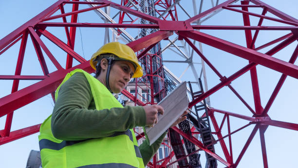 istock Female Engineer working on the field near a Telecommunications tower. 1213293190