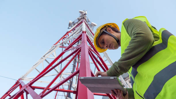 istock Female Engineer working on the field near a Telecommunications tower. 1213293195