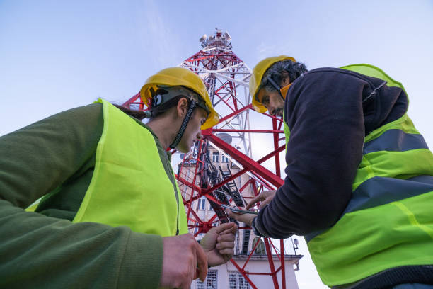 istock Engineers working on the field near a Telecommunications tower. Teamwork. 1213293223