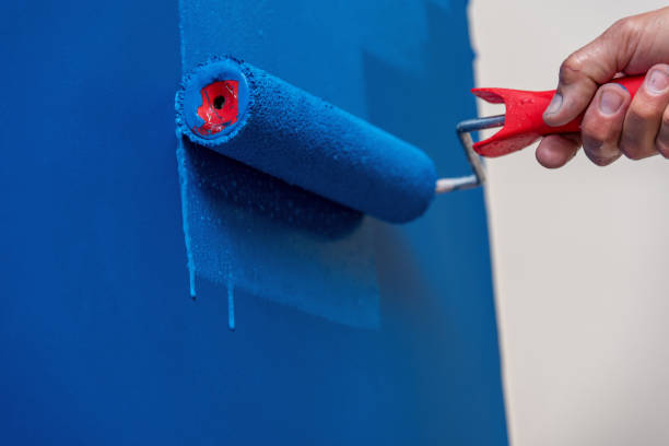 istock workman painting the wall in blue 1213293487