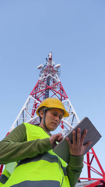 istock Female Engineer working on the field near a Telecommunications tower. 1213293625
