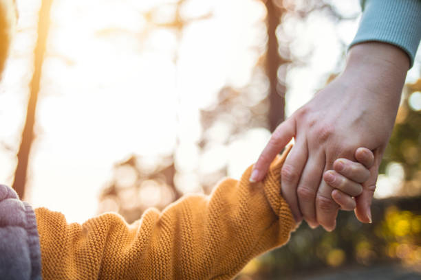 madre che tiene mano ai suoi ragazzini - holding hands human hand child mother foto e immagini stock