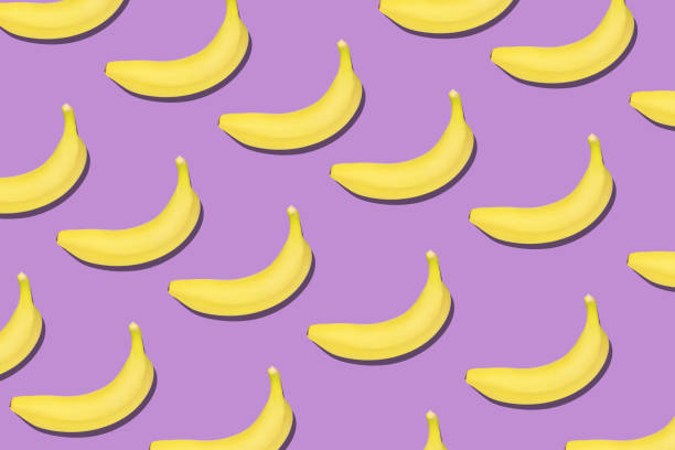 istock Colorful fruit pattern of fresh yellow bananas on violet background. 1213296238