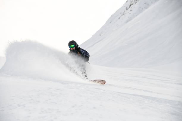 istock Freerider in full equipment rides on a snowboard in mountains 1213296248