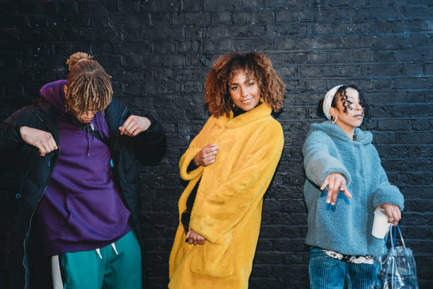 istock Three friends dancing in the city against a black brick wall 1213297927