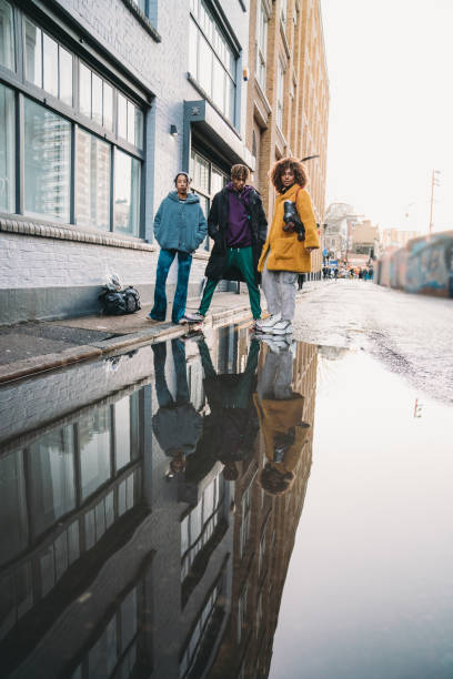istock Three hip friends reflected in a puddle in the city 1213297945