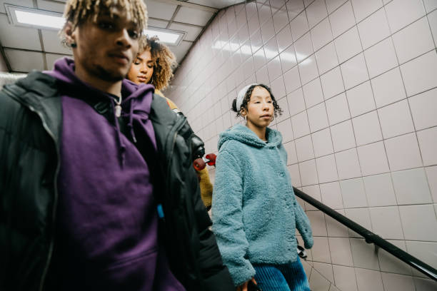 istock Three friends coming down the stairs in subway 1213297959