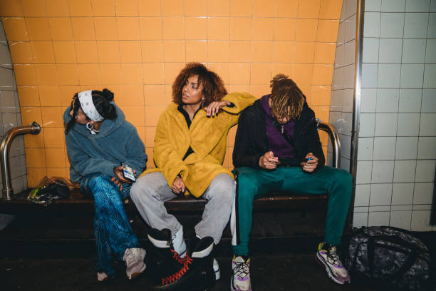 Three friends waiting for the train in a subway station