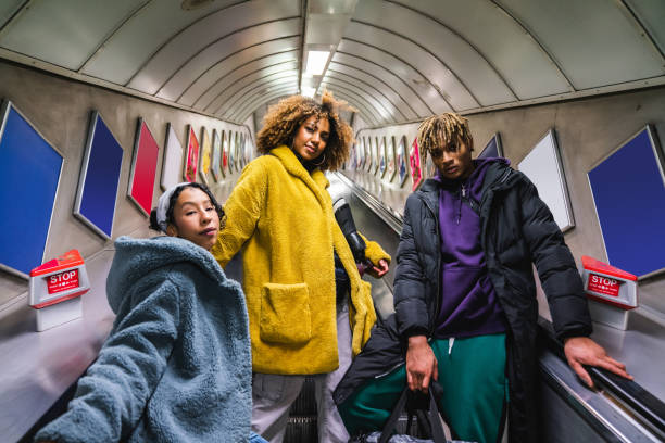 tres amigos en escaleras mecánicas en el metro - london underground fotografías e imágenes de stock