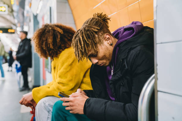 istock Young man playing with a smartphone while he's waiting for the subway train 1213297984