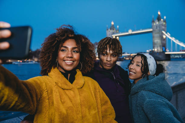 trzech młodych dorosłych przyjaciół hip biorąc selfie w londynie w pobliżu tower bridge - london england england street light telephone zdjęcia i obrazy z banku zdjęć