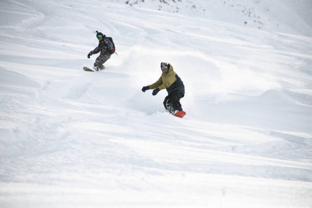 istock Two freeriders sliding down the mountain slope 1213298196