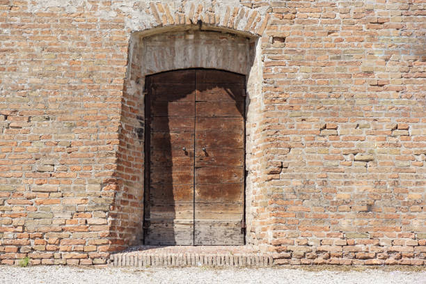 istock Old Wooden Door on Grunge Brick Wall 1213299330