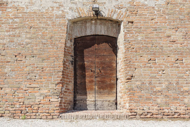 istock Old Wooden Door on Grunge Brick Wall 1213300109