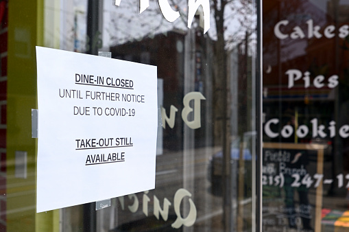 Philadelphia, PA, USA - March 18, 2020; Sign in windows of a local restaurant in the commercial district of the Mt Airy neighborhood in Northwest Philadelphia, PA.