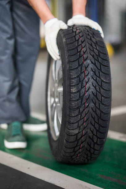 istock Auto mechanic carrying tire in tire store 1213301006