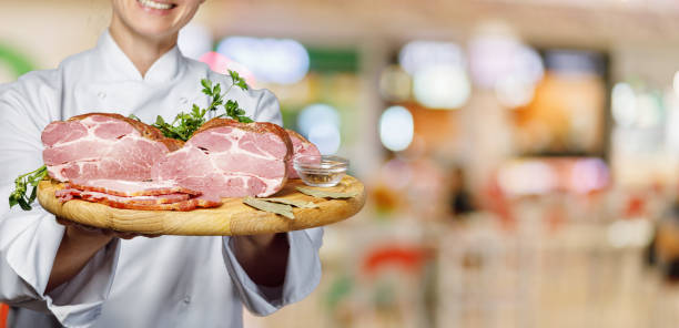 istock Cook shows hams on a wooden board . 1213302439