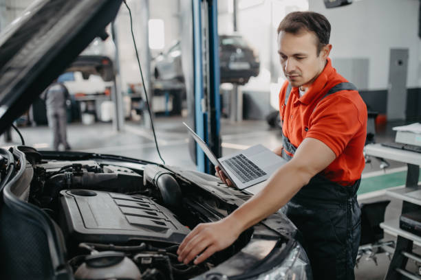 istock Auto mechanic using laptop with blank screen near car 1213305702