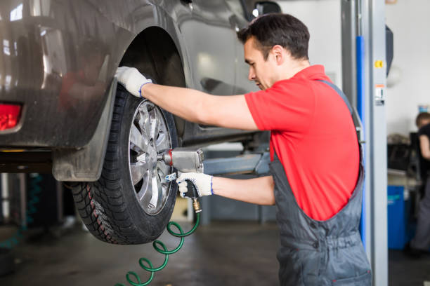 istock Auto mechanic in his workshop changing tires or rims at service 1213305872