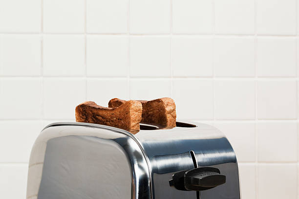 zwei scheiben toast in toaster - getoastet stock-fotos und bilder
