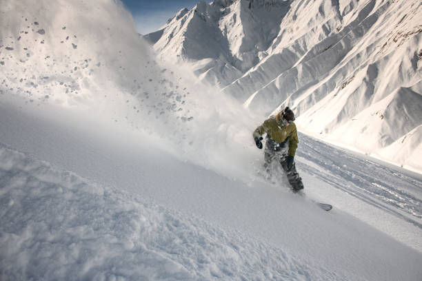 istock Snowboarder slipping down the mountain through the snow 1213309527