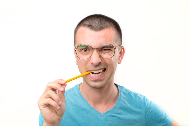 istock Young hispanic man in glasses is thinking about something with pencil 1213309702