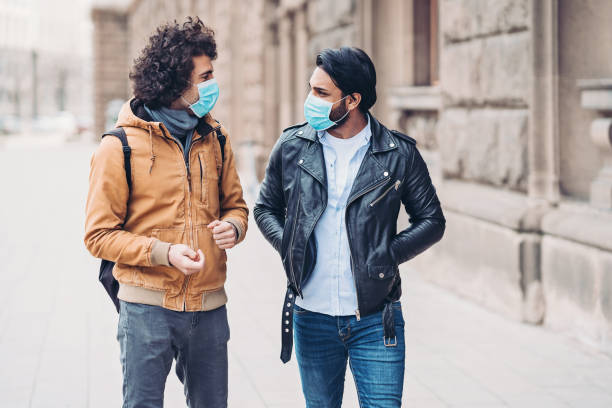 istock Men with protective masks walking outdoors 1213309853