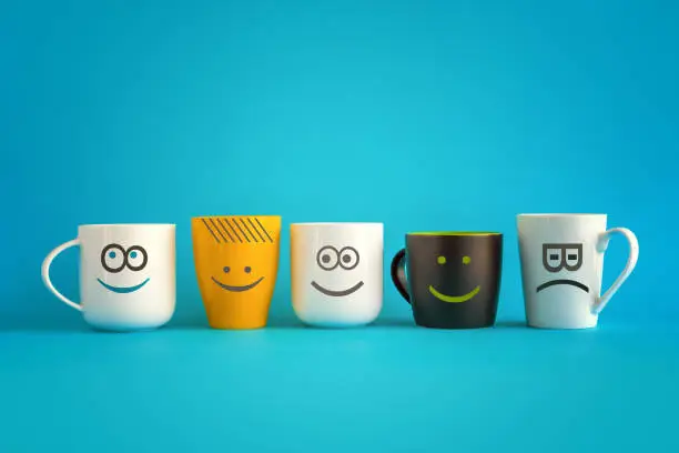 Photo of Coffee Cups with Happy and Sad Emoticons