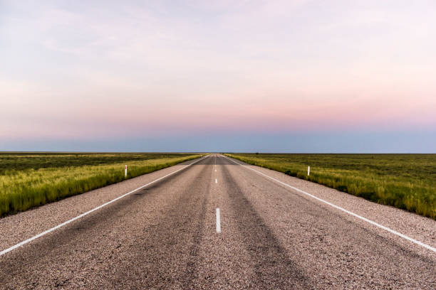 camino recto a través de la parte trasera de australia, después de una hermosa puesta de sol - downunder fotografías e imágenes de stock