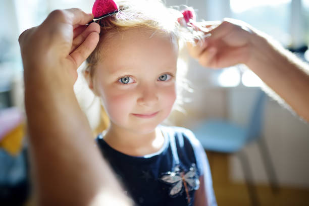 young handsome father making cute hairstyle for his little curly hair daughter - blond hair carrying little girls small imagens e fotografias de stock