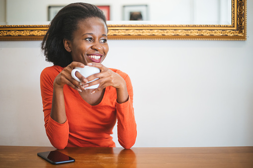 Portrait of a beautiful african woman drinking coffee