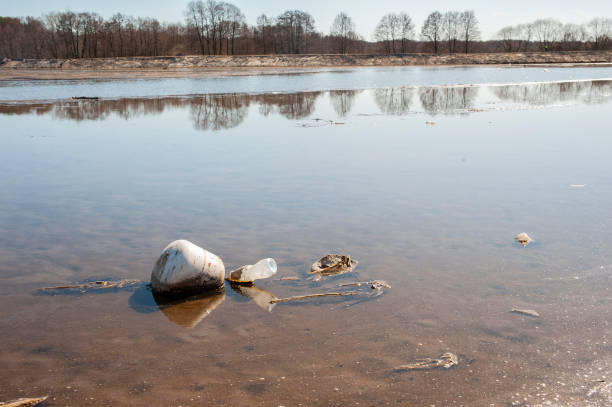 乾燥した湖の底に廃棄物の多く。環境汚染と干ばつ問題。 - global warming drought riverbank dirt ストックフォトと画像