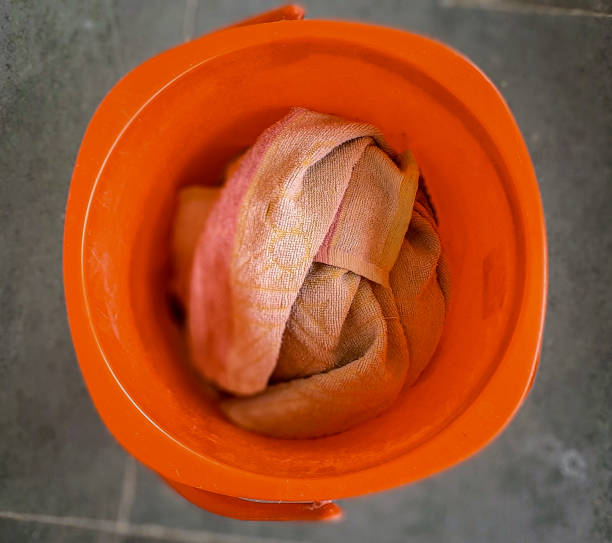 Red water bucket with towel in it as viewed from the top