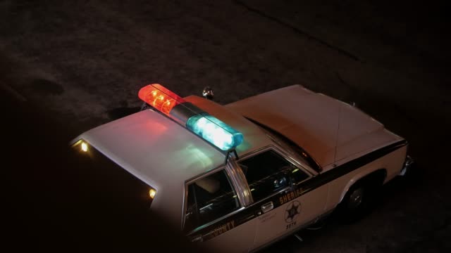 Sheriff's old police car with lights on.