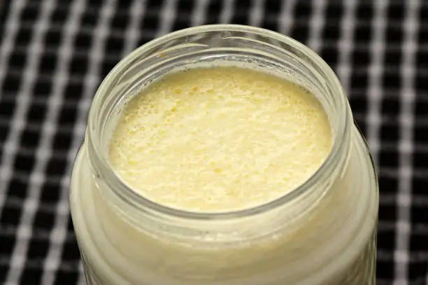 Close up creams on Turkish yogurt in jar.