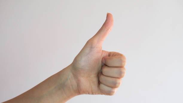 istock Female left hand. Thumb up on white background. OK gesture. 1213329560