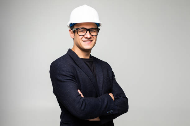 istock Confident man engineer wearing protective helmet holding hands crossed looking away isolated over white background. 1213329802