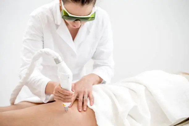 Dermatologist Removing Vascular Veins on Woman's Leg with Laser Treatment