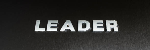 istock Word leader spelled with chrome letters on black background in a conceptual image of leadership 1213334096