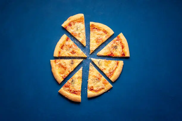 Photo of Sliced pizza on blue background. 4 cheese pizza slices