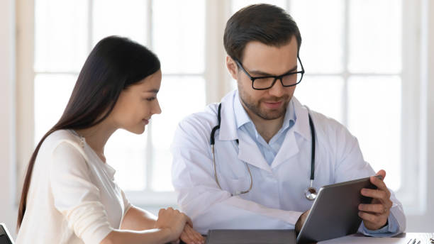 istock Pleasant doctor sharing treatment ideas with young woman. 1213336873