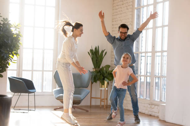 istock Young married couple having fun, watching little daughter dancing. 1213336930