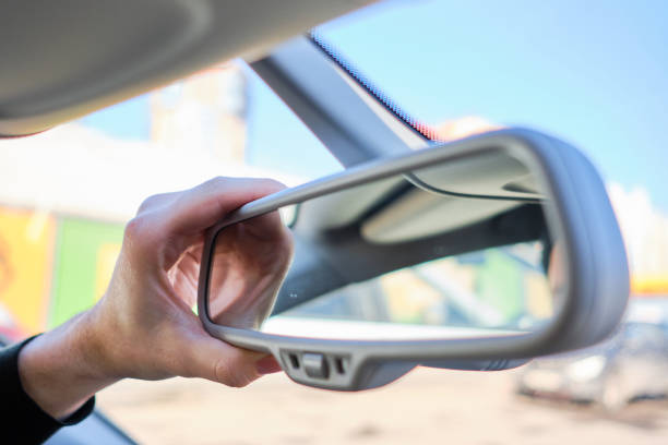 istock A man in a modern car. Hand adjusts the rearview mirror. 1213337219