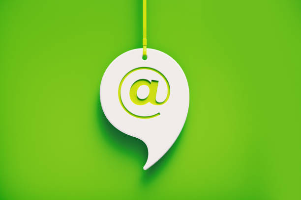 White speech bubble hanging over green background. At symbol imprinted on chat bubble. Horizontal composition with copy space.