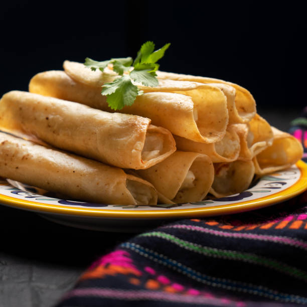 istock Mexican potato and cheese fried tacos also called flautas on dark background 1213343682